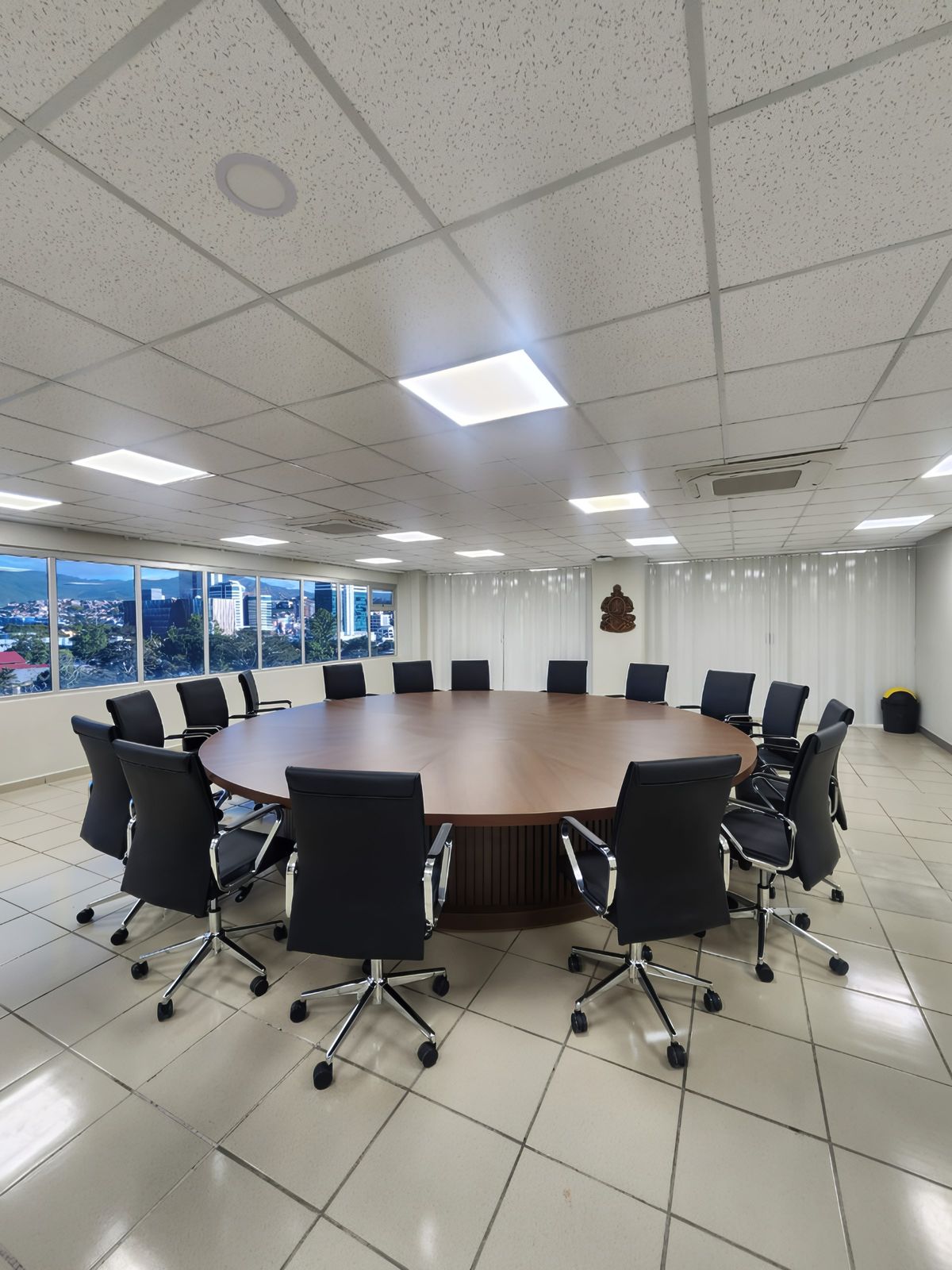Fotografía de una sala de reuniones con mesa redonda y sillas negras