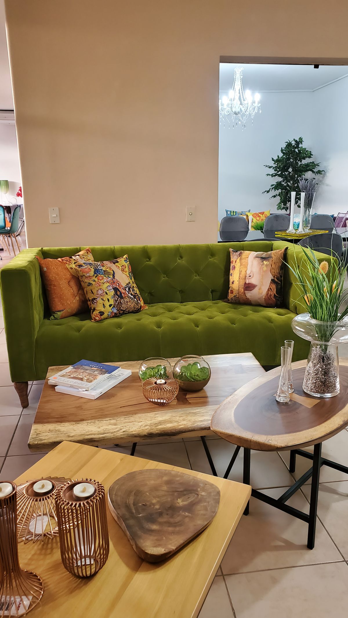 Estar con sofá verde, cojines cálidos y mesa auxiliar de madera