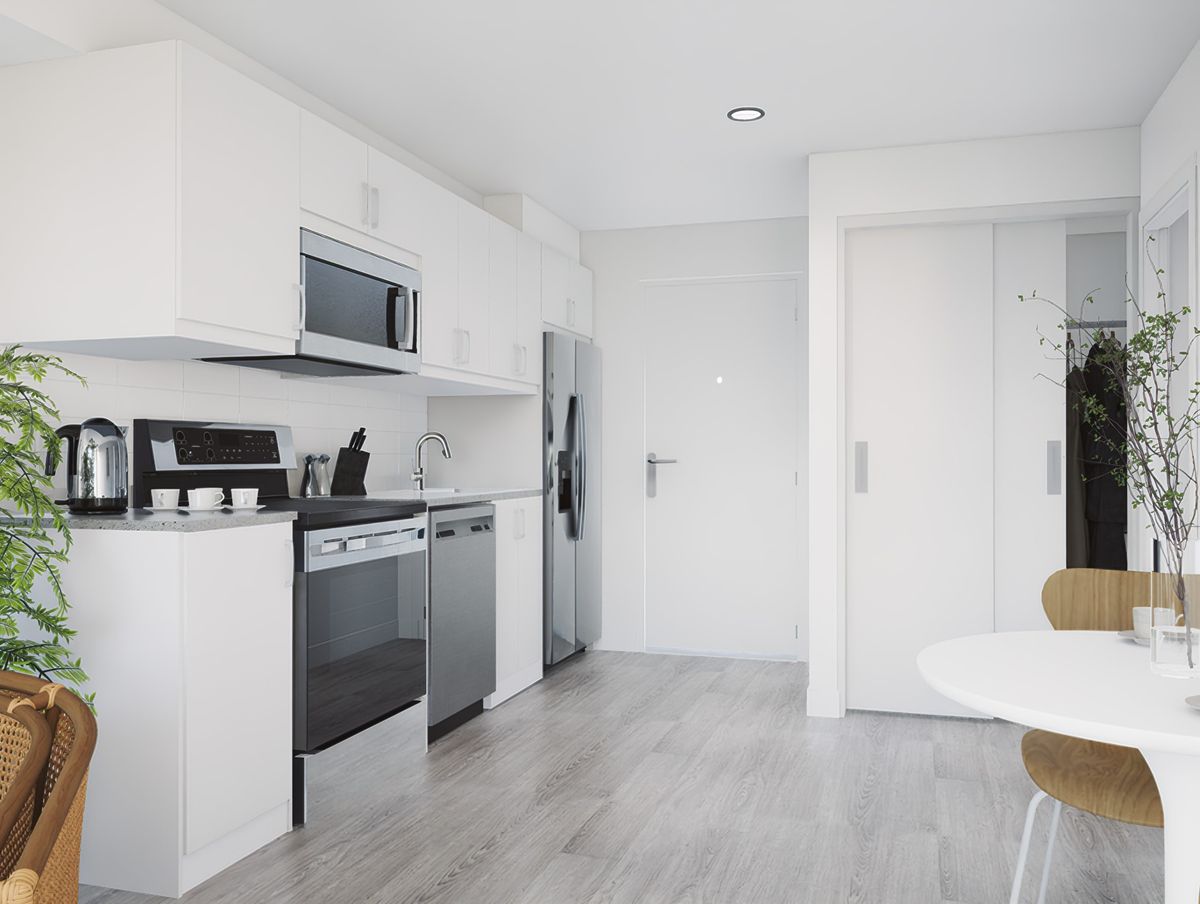Cocina blanca con electrodomésticos de acero y piso claro