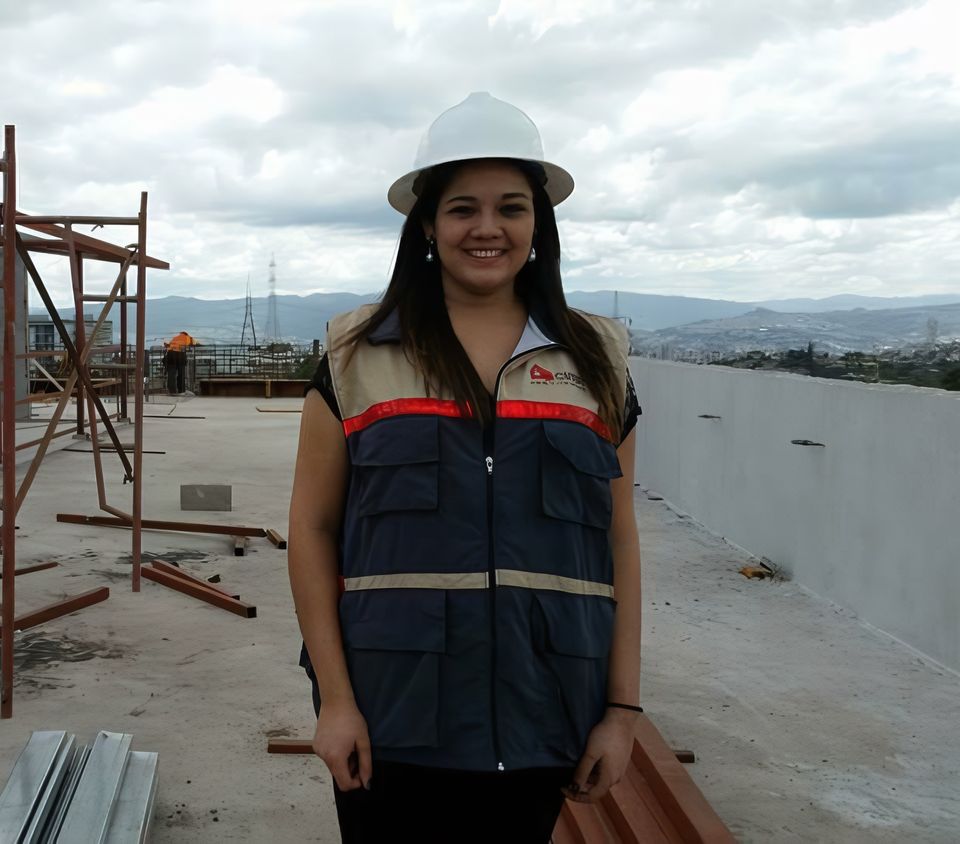 Ruth Narváez en obra con chaleco y casco, junto a andamios de estructura metálica